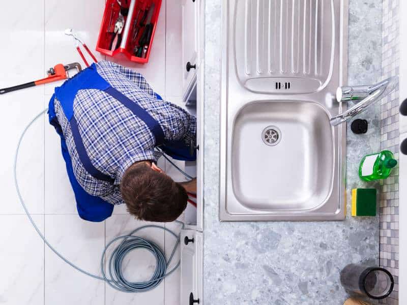 plumber cleaning kitchen drains