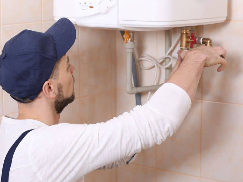 plumber giving water heater a tune-up